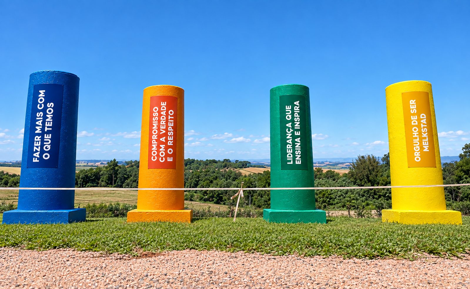 Totens coloridos com os quatro pilares do Somos MelkStad pintados na fazenda